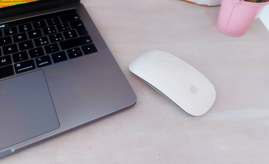 Apple Magic Mouse 1 junto a MacBook Pro en escritorio